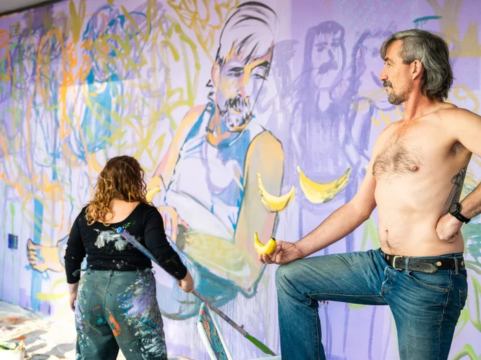 Alison Mooney and her model as she paints The Daily Muse mural in Maroochydore