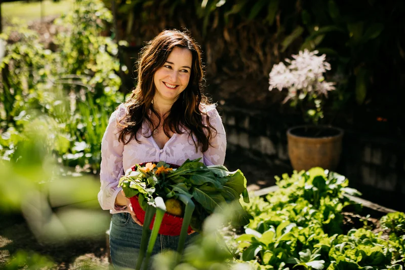 A resident enjoying time in the garden with a basket of harvested home produce.