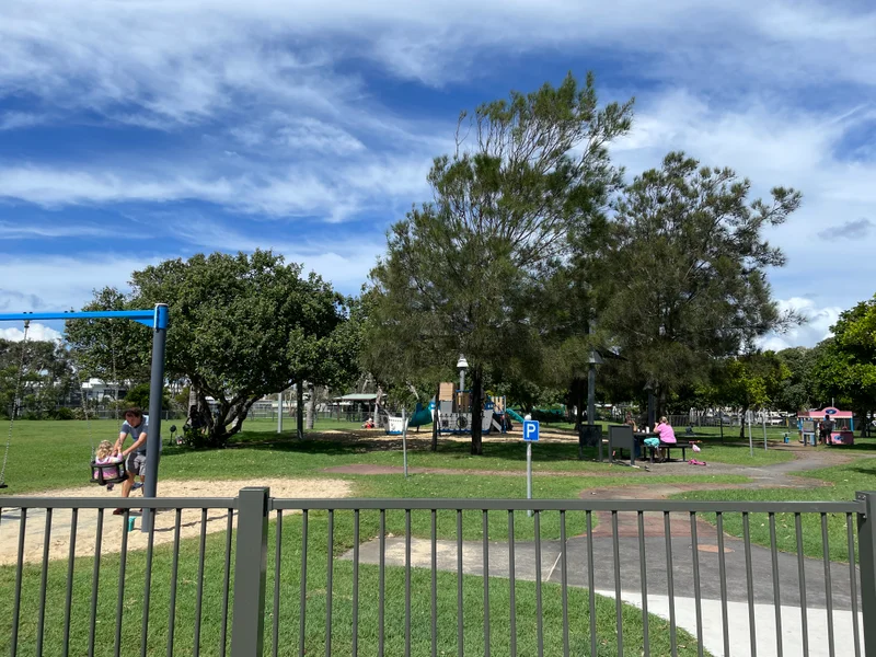 Fenced playground with swings, bike education track and play equipment