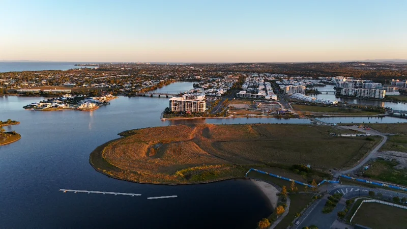 Aerial view of Birtinya. Showing the canals and land space and residential area with blue skies and horizon view.