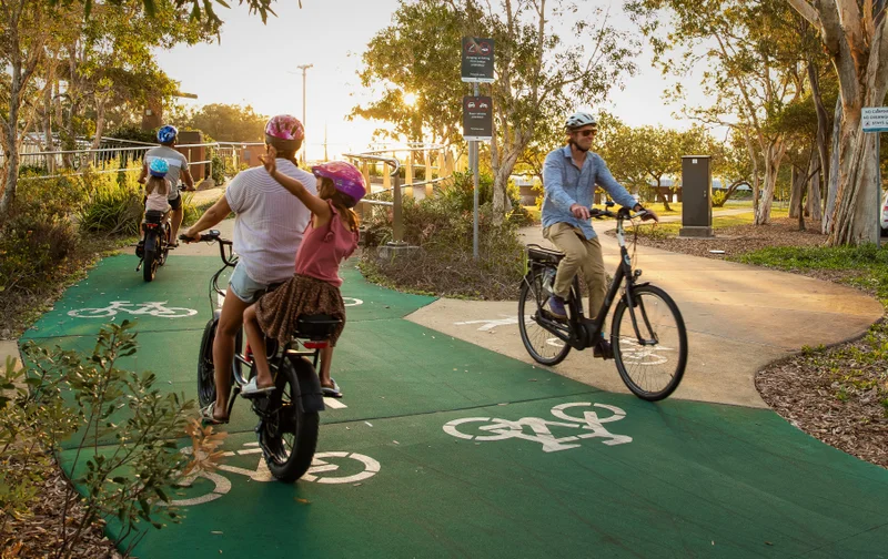 Bicycle riders going in both directions on a green bike path.