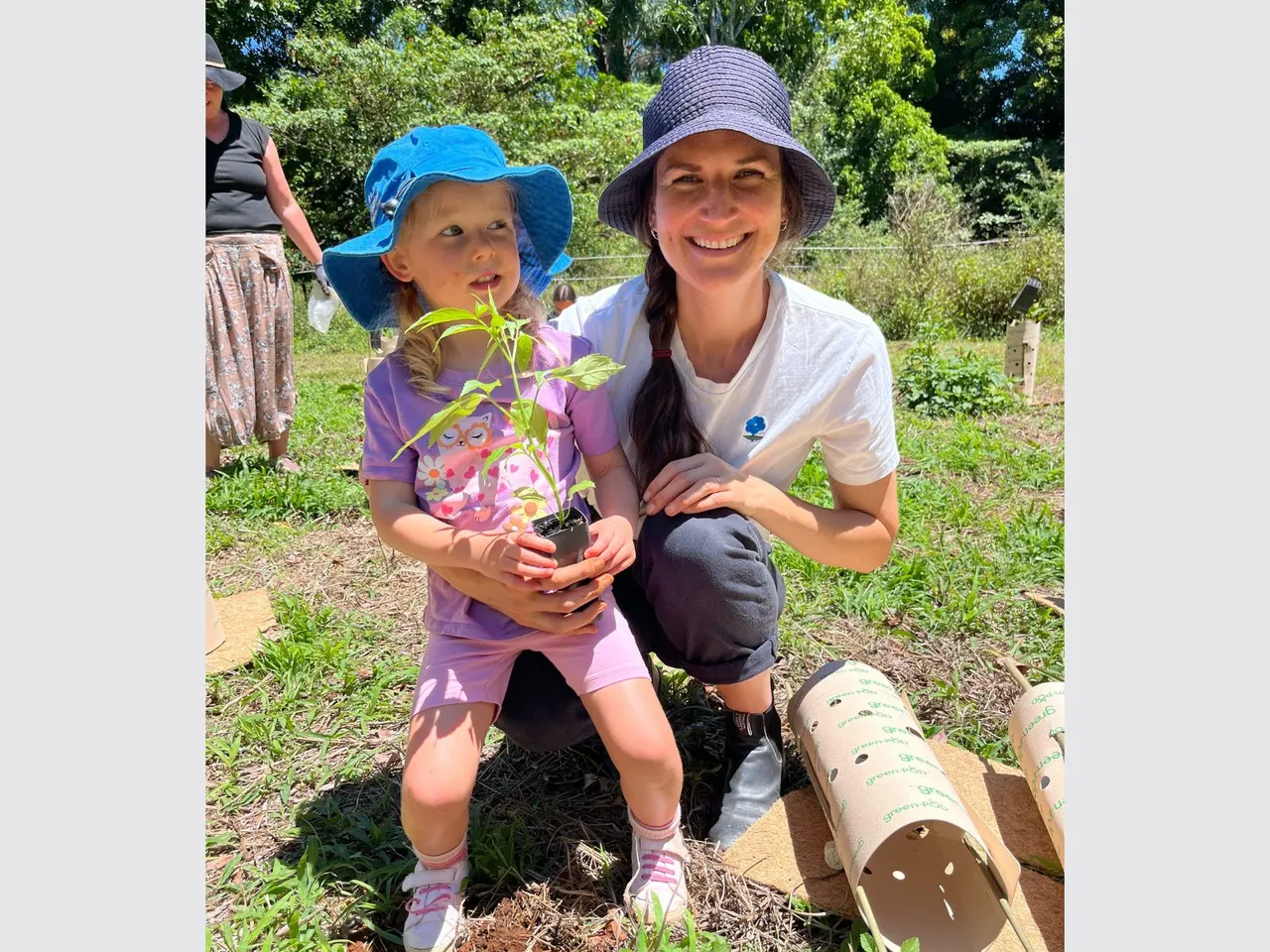 A woman and young girl hold a seedling.