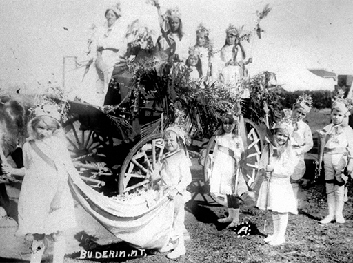 Mons school float, Buderim Carnival procession, 1918. Wattle Queen seated on wagon owned by A.E. Vise and driven by Amy Wright (teacher). S. Vise pictured standing to the right of the wagon. Mons school children in the foreground.