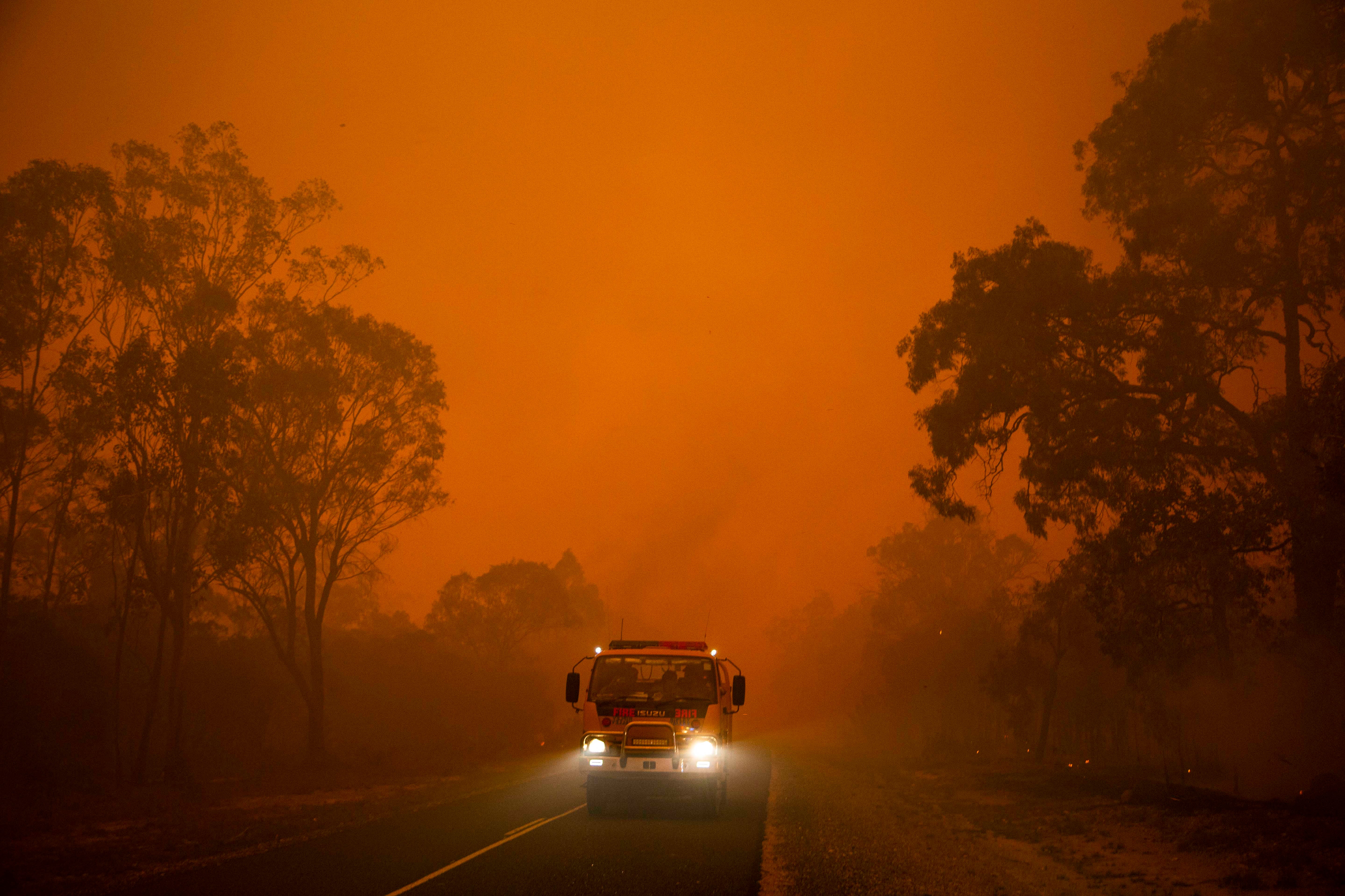 Fire truck moving through active bushfire