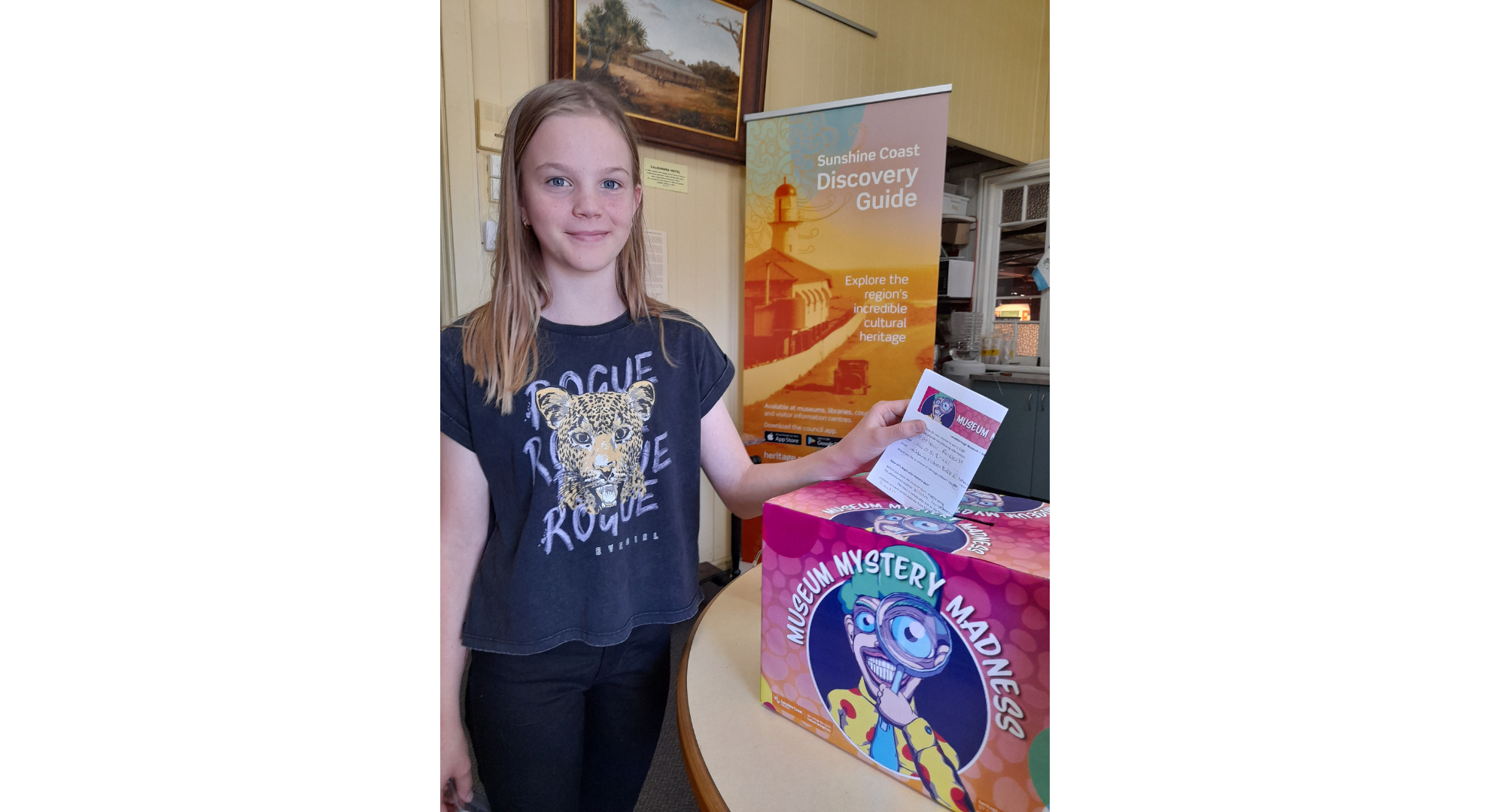 Young girl with discovery guide sign in the background