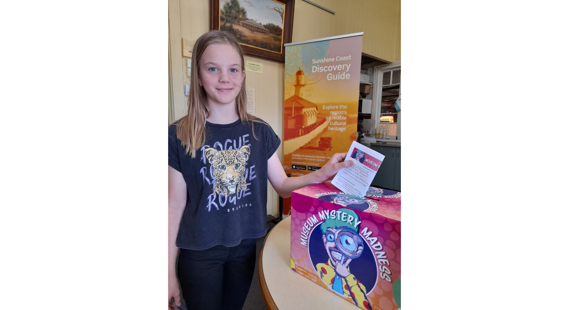 Young girl with discovery guide sign in the background