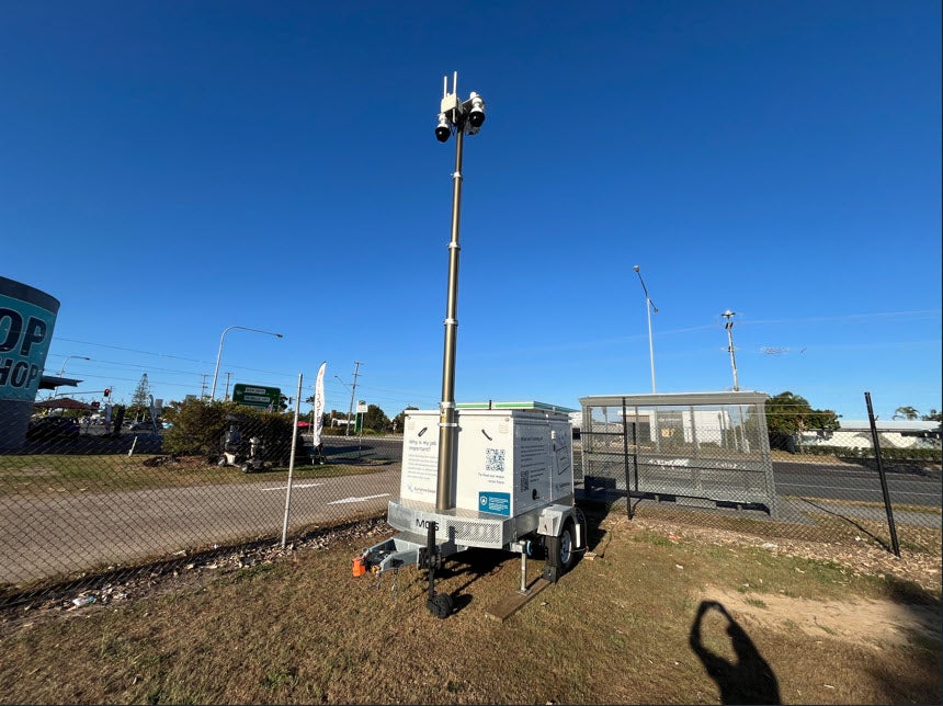 Trailer parked in field beside road