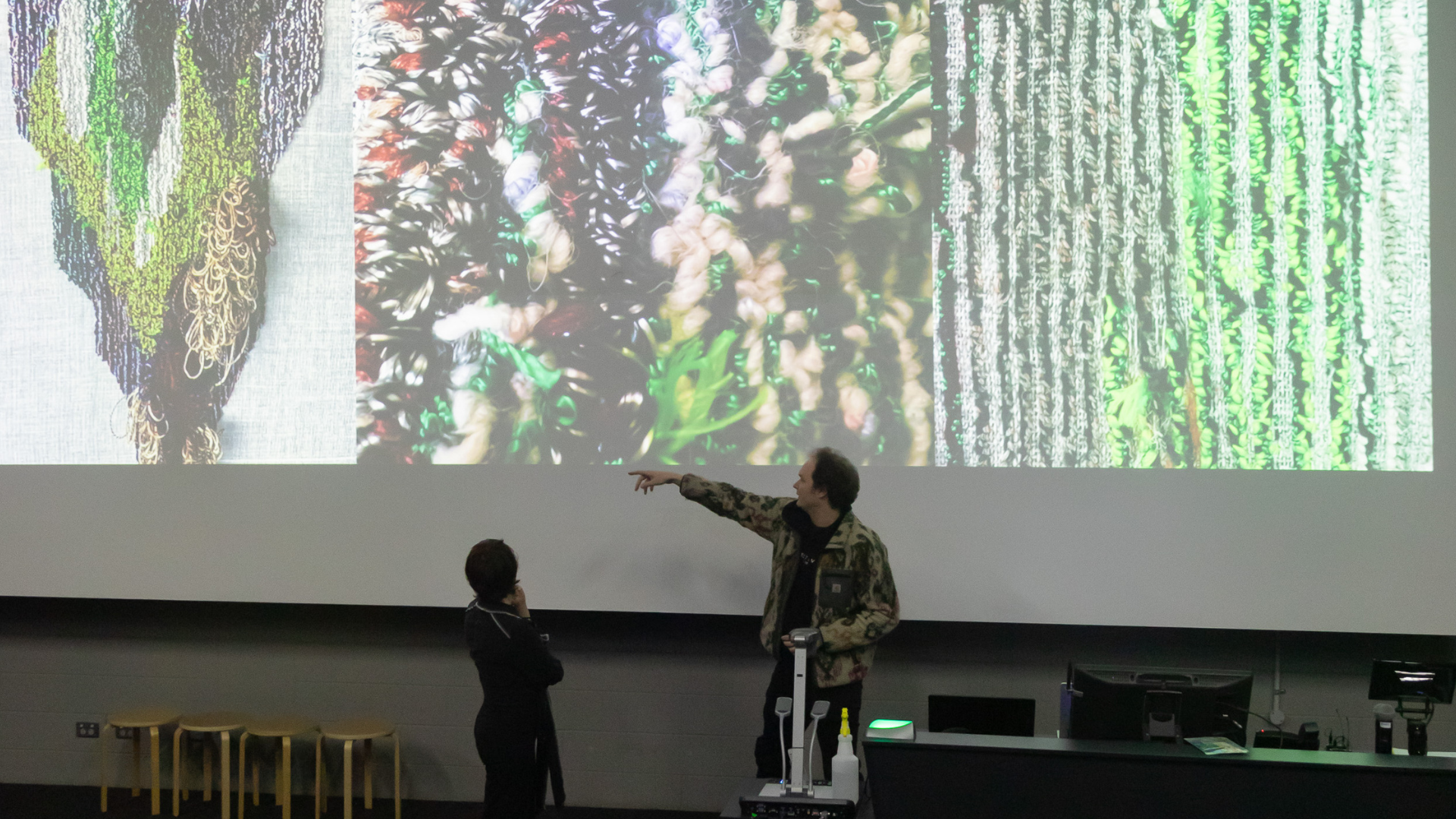 Participants discuss work shown on a big screen_FutureNow 2024