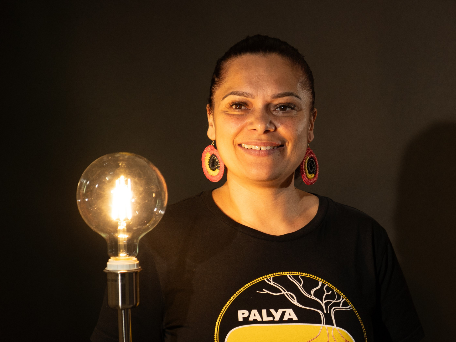 Shine a Light on Racism campaign patron Mundanara Bayles, holds a golden lamp, helping to shine a light on racism.