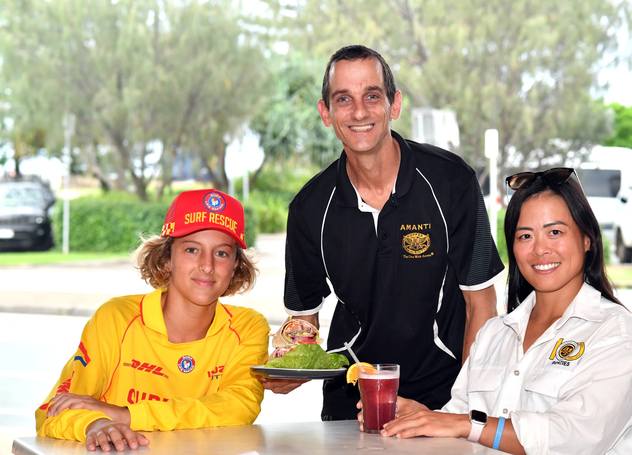Aussies competitors Nick Carter (L) and Asako Ono (R) from Alexandra Headland Surf Club with Black Bunny Café owner Glen Elliott