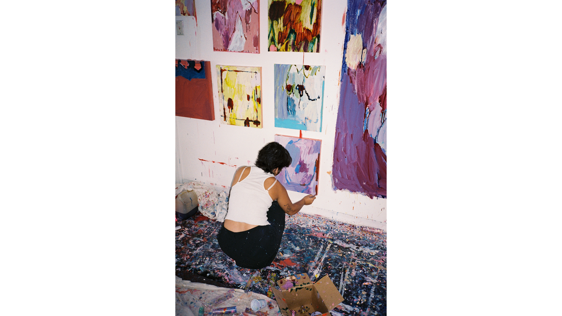 Artist in her studio hanging works