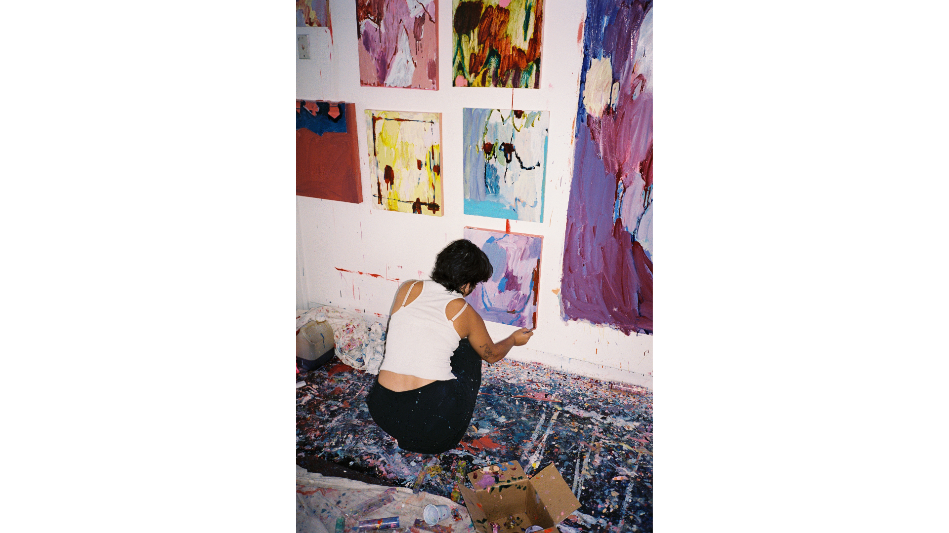 Artist in her studio hanging works