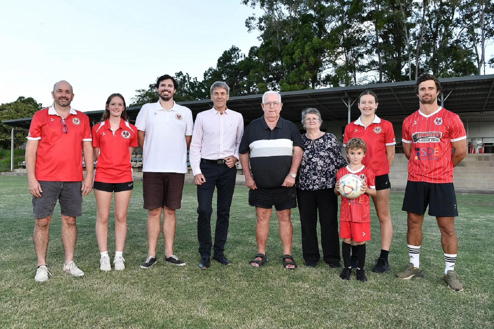 (Left to right) NYU Football Club President Jeff McColl with his daughter Lily McColl, Lachlan O’Keefe, Sunshine Coast Council Division 10 Cr David Law, Peter and Jenny Harth, their great-grandson Ari Harth (at front), Sophie Day, and Peter and Jenny’s grandson Jono Harth.