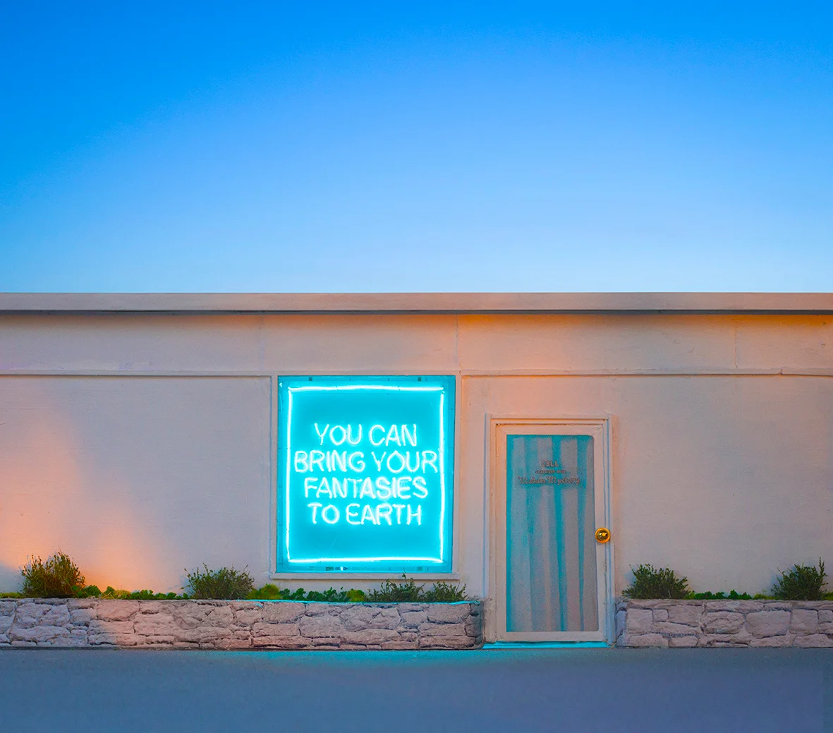 Earth coloured building with a sign 'You can bring your fantasies to earth'