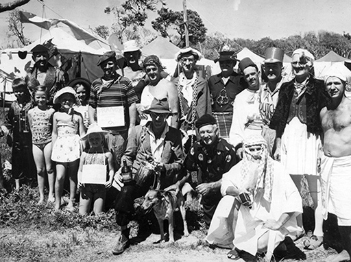 Children and members of the North Caloundra Deep Sea Amateur Fishing Club and North Caloundra Surf Life Saving Club in fancy dress, Moffat Beach camping ground showing Club members in costumes for a Christmas parade. Moffat Beach, ca 1960.