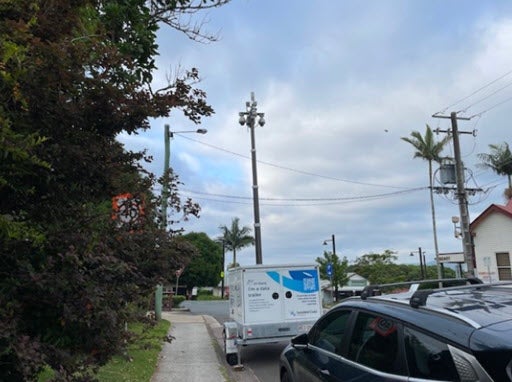 Trailer with a mast parked on side of road