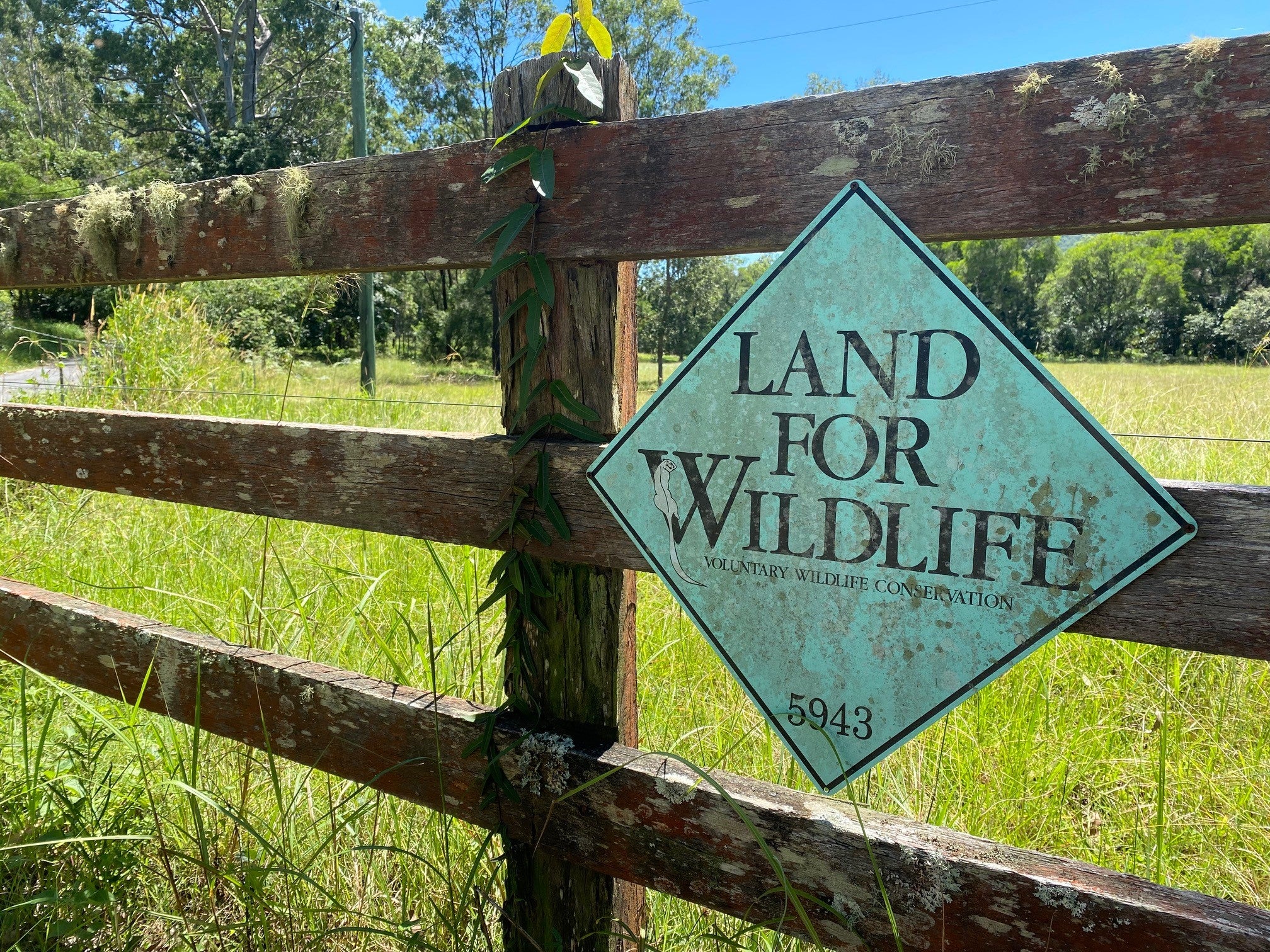 A Land for Wildlife sign attached to a rural fence.