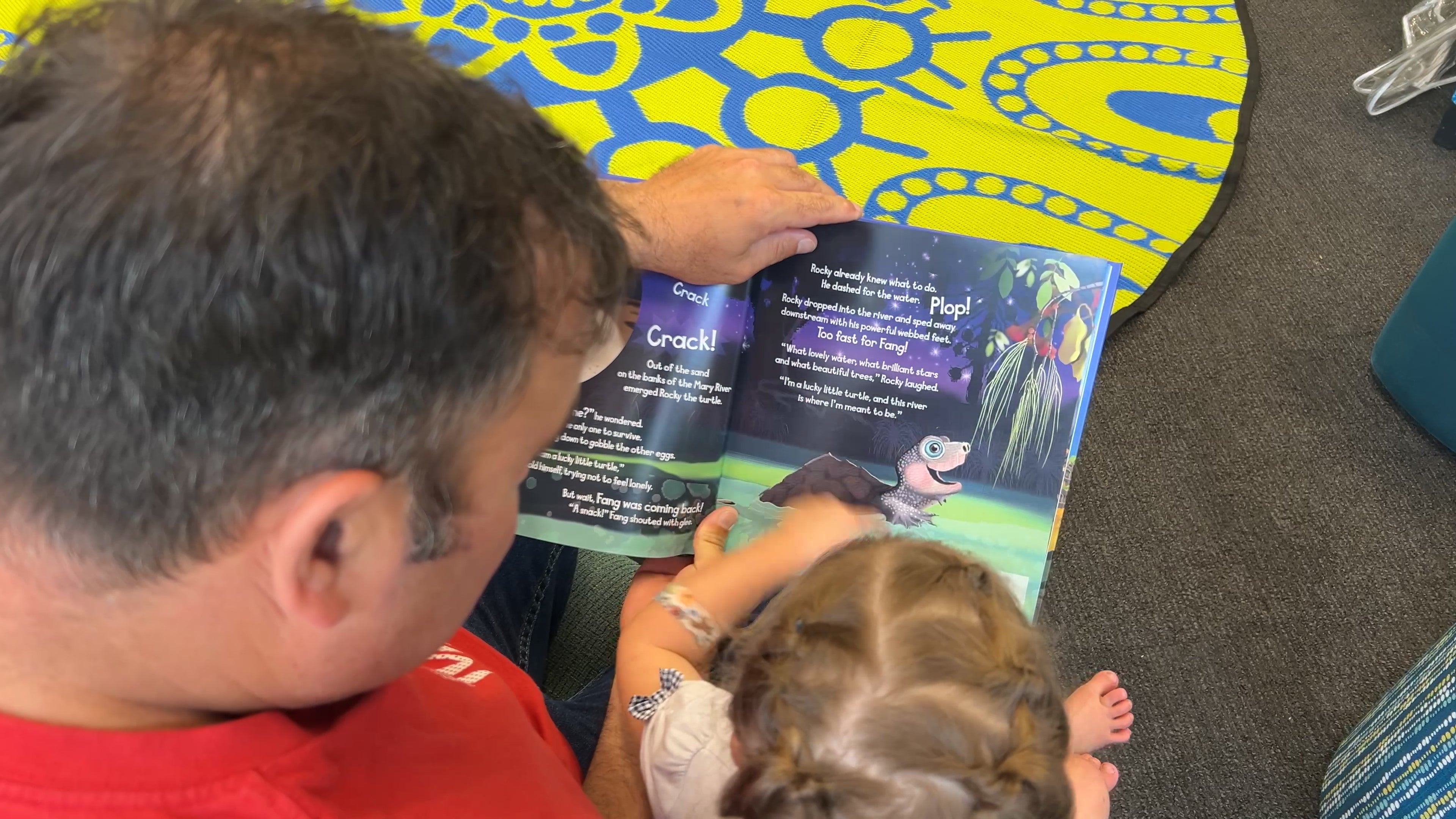 A father and daughter read Rocky and the River in Peril.