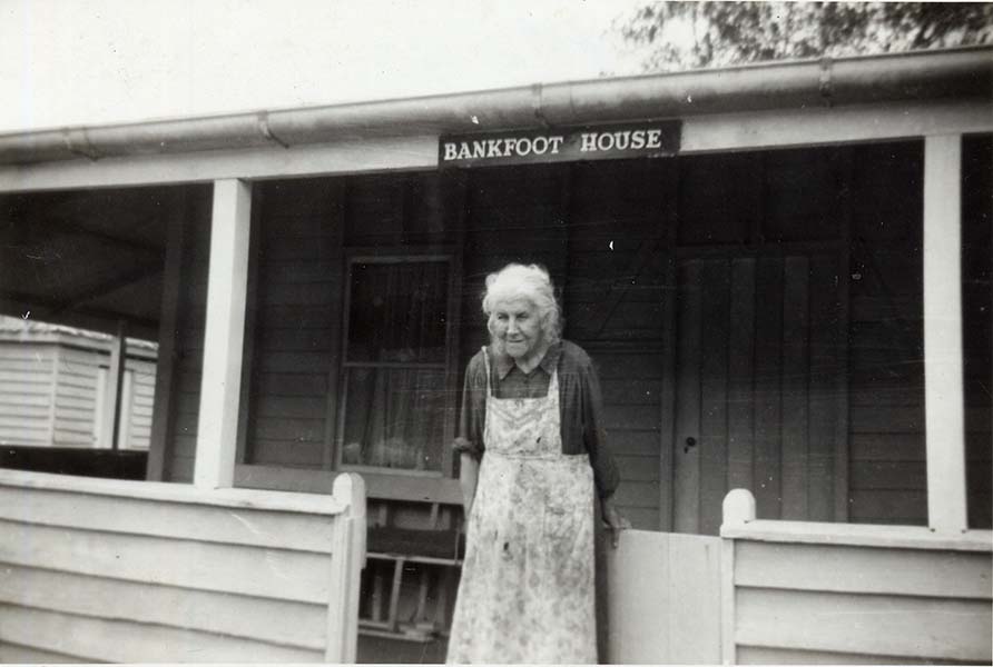 Clementina Burgess standing on the front verandah of Bankfoot House in 1960. By this time the house had received its first coat of exterior paint. The balustrade, posts, windows and front door all show the tell-tale signs of a painted finish. This initial colour scheme was applied during the late 1950s.